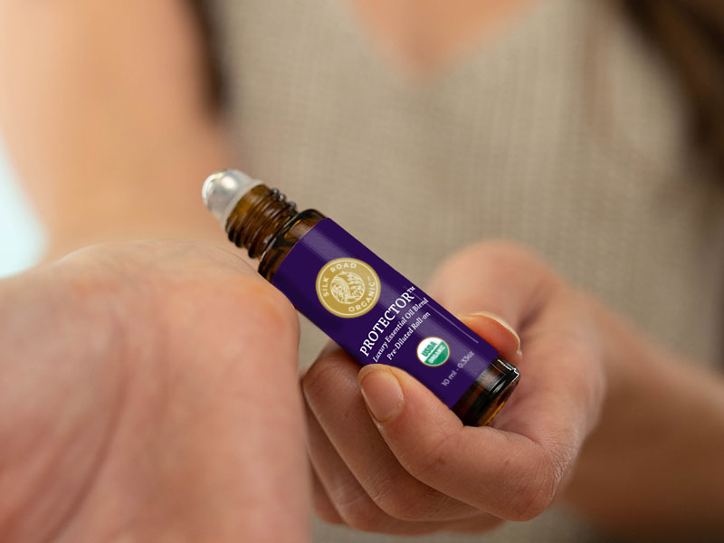 applying protector essential oil roll-on to wrist