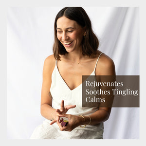 Woman applying essential oil  to her hand with a white background