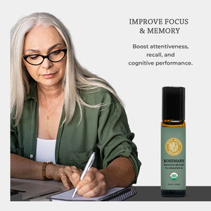 Woman with glasses taking notes, next to a bottle of Rosemary essential oil, on a white background. Improve Focus & Memory