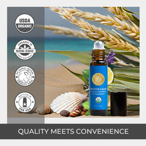 Bottle of 'Breathe Calm' essential oil with natural elements and certification logos on a beach background. rollerball natural quality pure camphor extract amber glass bottle uv protect usda certified organic