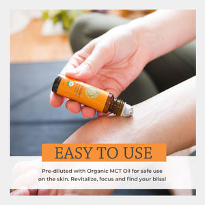Hand holding a small bottle of essential oil with text about its use and benefits. easy use apply eau de parfum pulse points temple neck bicep wrist rejuvenate