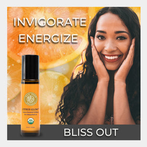 Roll-on bottle with citrus glow product and woman smiling in front of oranges, text 'Invigorate', 'Energize', 'Bliss Out'. romatherapy bright joyful scent cleanse invigorate detoxify skin care cosmetic