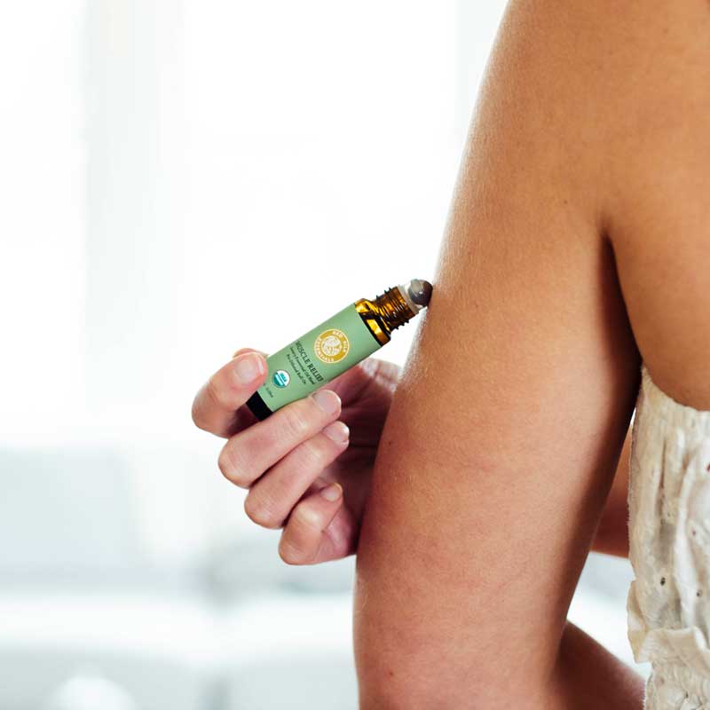 pain relief solutions woman applying muscle relief organic essential oil roll-on