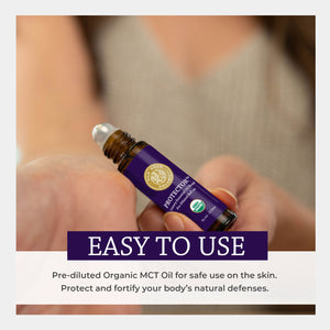 Roll-on bottle of Protector essential oil held by a person with promotional text. easy safe topical apply skin diluted fractionated coconut protect fortify natural defense