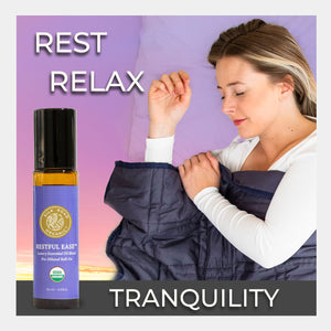 Woman holding a blanket with a bottle of essential oil blend labeled 'Restful Ease' on a purple background. use aromatherapy calm nerves bedtime tranquility wellness unwind sleep relief aid